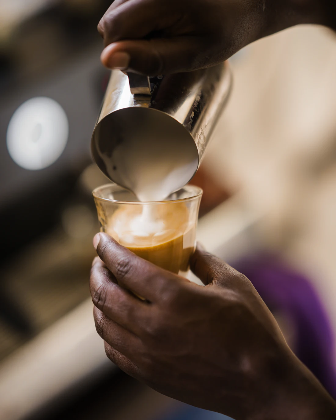 Tom pouring steamed milk into a cortado