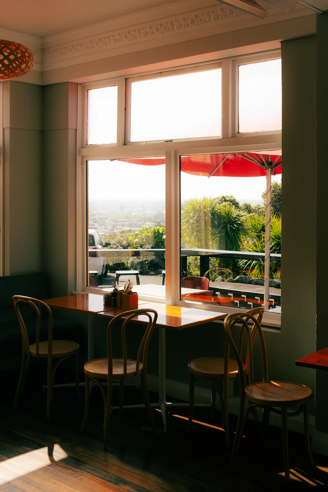 Sunlit window bar with wooden chairs looking out over the street
